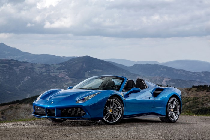 Blue Ferrari 488 Spider convertible on a mountain road