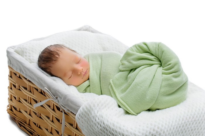 Newborn baby sleeping in a wicker basket