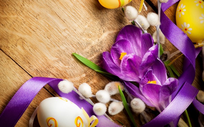 Easter eggs and crocuses on wooden background