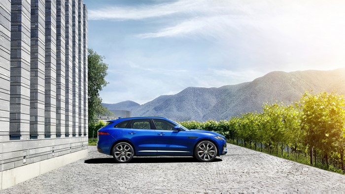 Blue Jaguar F-Pace S parked by a modern building