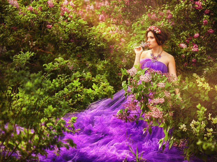 Woman in purple dress in lilac garden