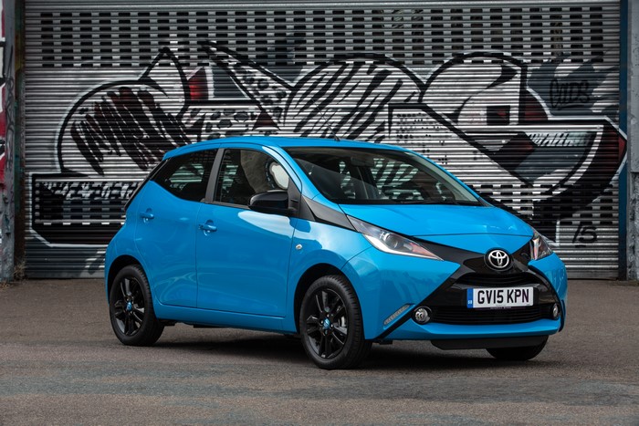 Blue Toyota Aygo X-cite with graffiti background