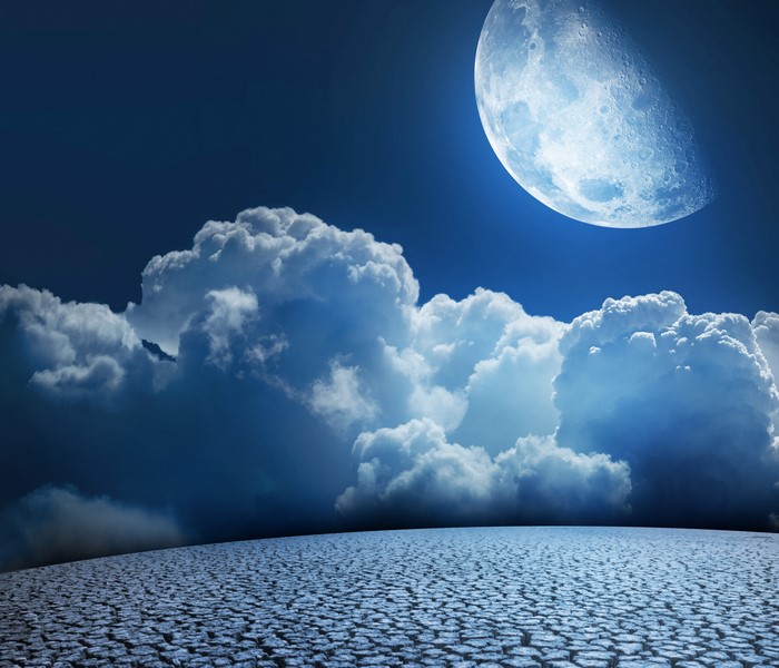 Moon and Clouds over Cracked Earth