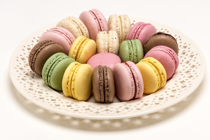 Many colorful macarons on a decorative plate