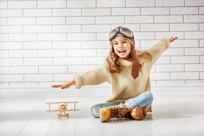 Girl in pilot costume with toy airplane