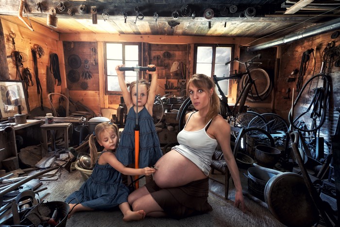 Pregnant woman and two girls in a workshop