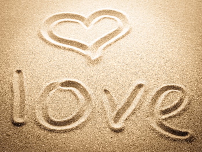 Heart and "love" written in sand