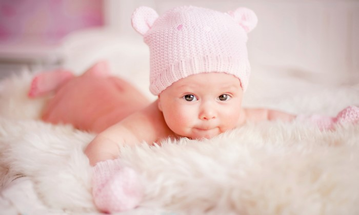 Baby wearing a pink bear hat and mittens
