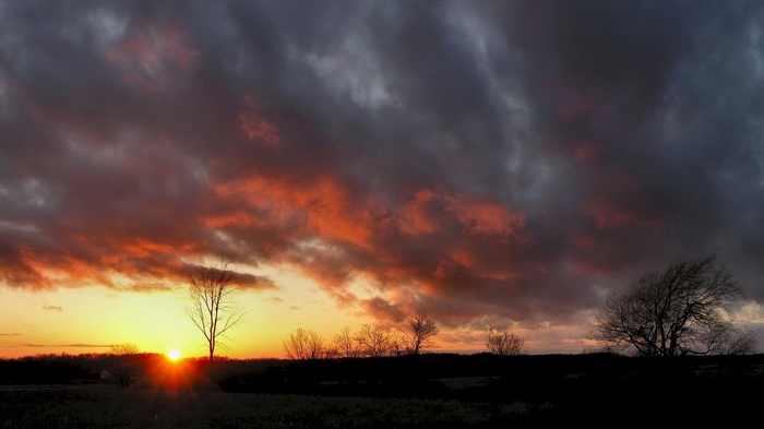 Sunset with dramatic clouds over a silhouetted landscape