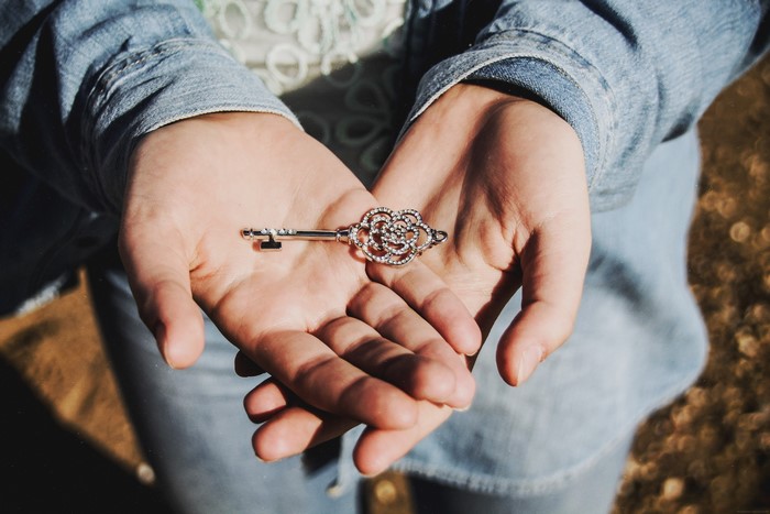 Hands holding a decorative key