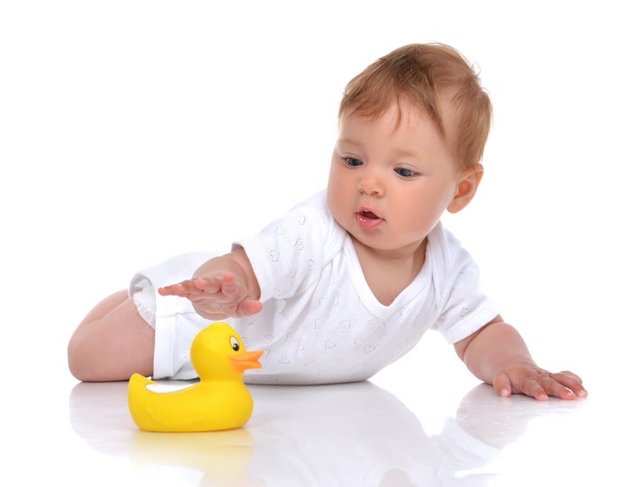 Baby reaching for a rubber duck