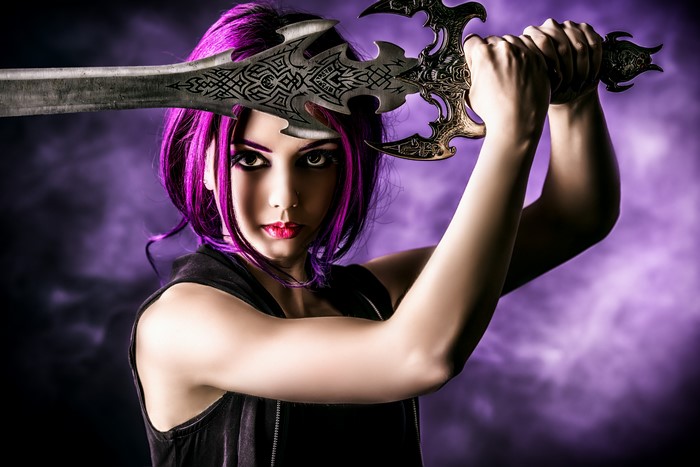 Woman with purple hair holding a sword