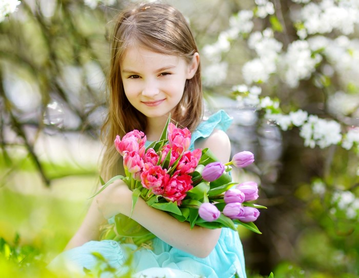 Girl holding tulips in a garden