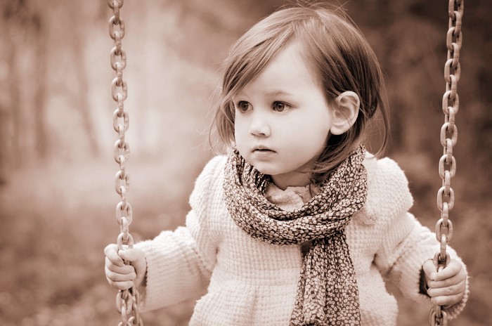 Little girl on a swing with chains