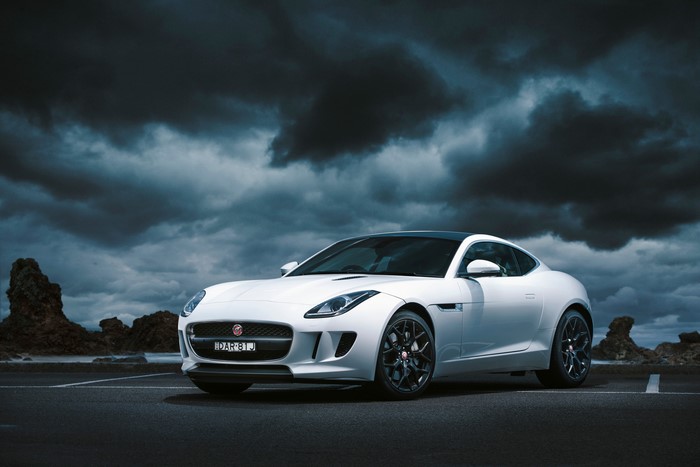 White Jaguar F-Type Coupe under dark clouds