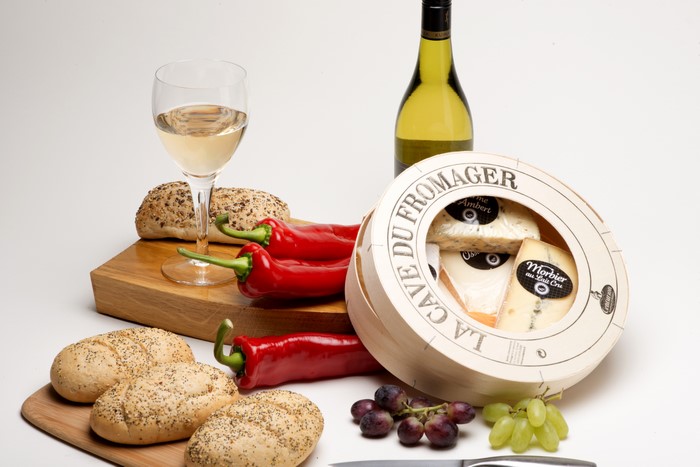 Still life with cheese, bread, wine, and peppers