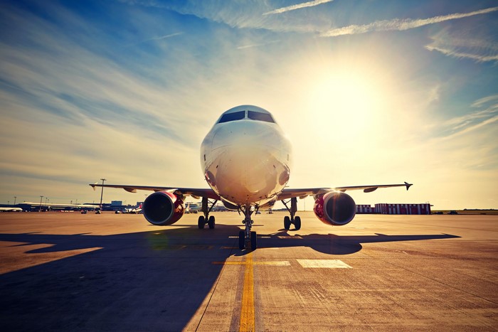 Airplane on tarmac at sunset