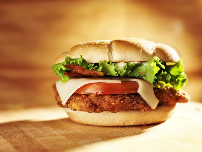 Chicken sandwich with cheese, lettuce, tomato, and bacon