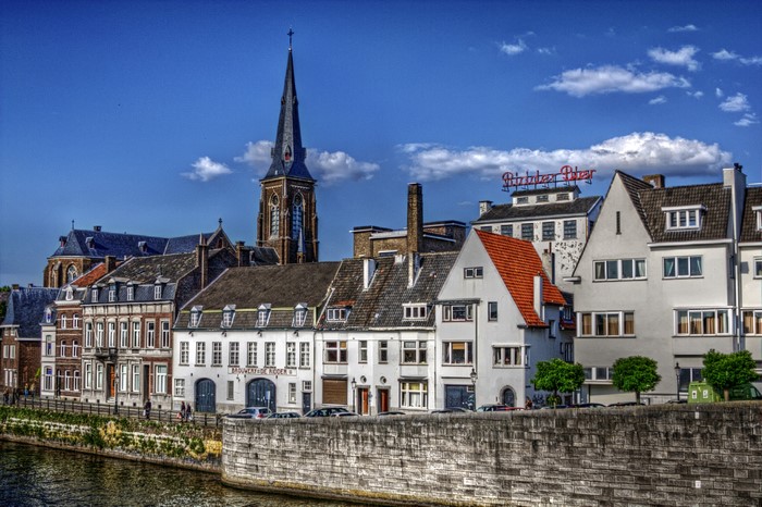 Maastricht, Netherlands canal with historic buildings and church spire
