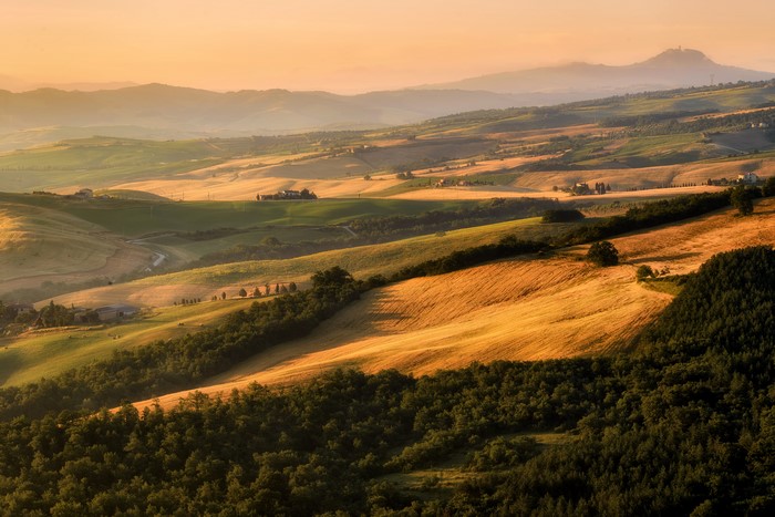 Tuscany landscape with rolling hills and fields at sunset