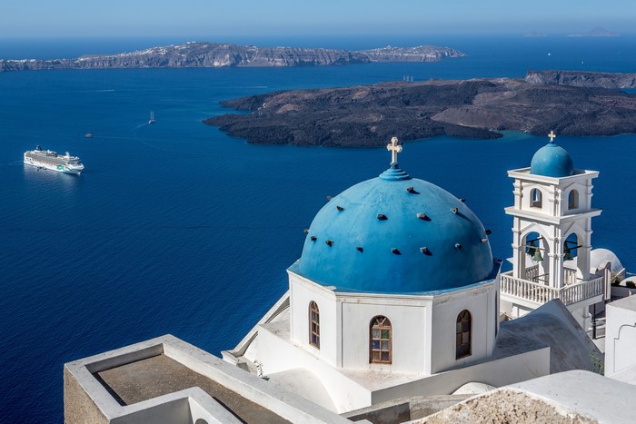 Blue domed church overlooking the Aegean Sea in Santorini, Greece