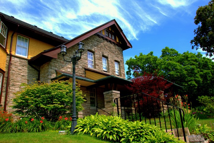 Stone house with yellow accents and garden in St. Catharines, Ontario