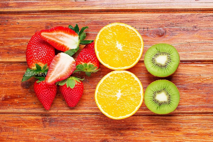 Strawberries, Oranges, and Kiwis on a Wooden Table
