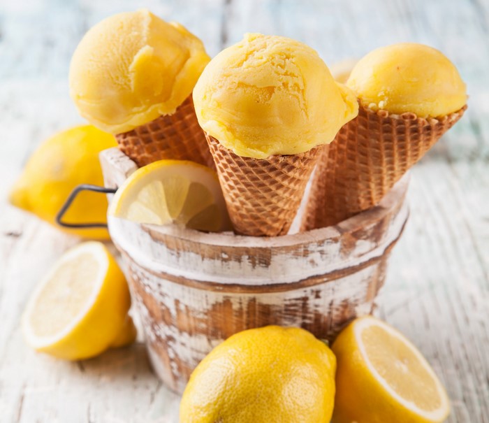 Lemon ice cream cones in a wooden bucket with lemons
