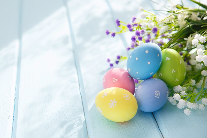 Easter Eggs and Flowers on Blue Wooden Surface