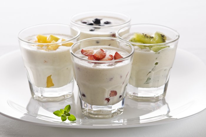 Four glasses of fruit yogurt on a plate