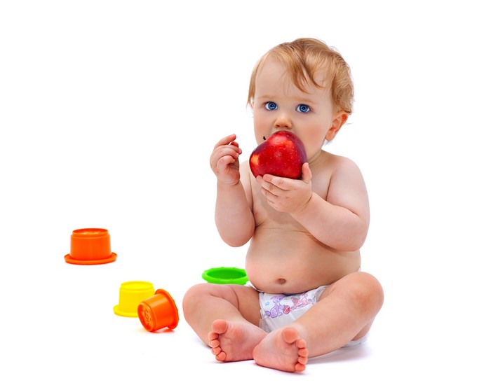 Baby eating an apple with toys
