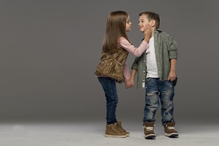 Two children, a girl and a boy, holding hands