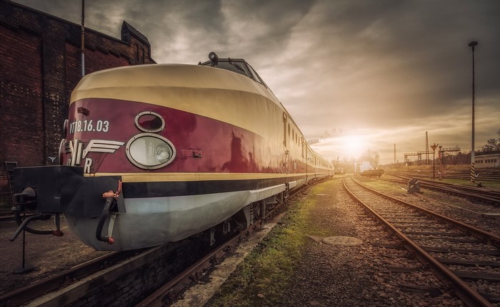 Vintage train on railroad tracks at sunset