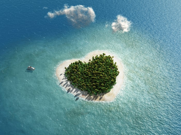 Heart-shaped island with palm trees and a boat