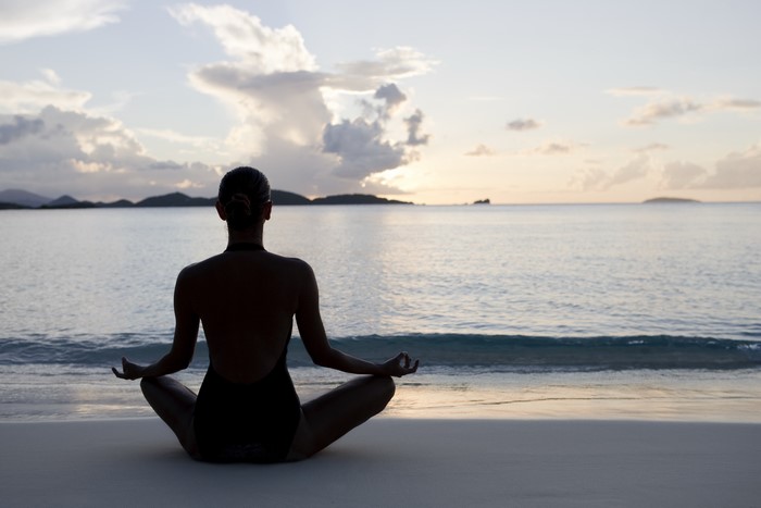 Woman in Lotus Position on Beach at Sunset