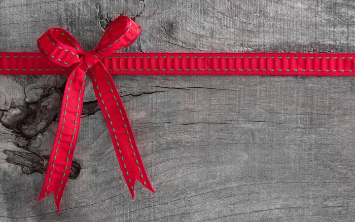 Red ribbon bow on wooden background