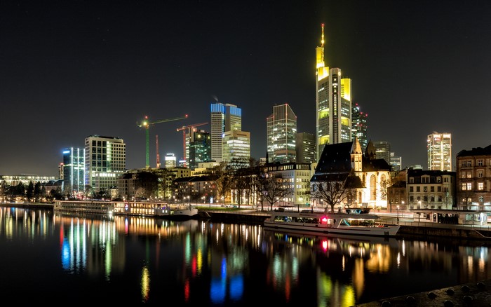Frankfurt skyline at night with river and ships