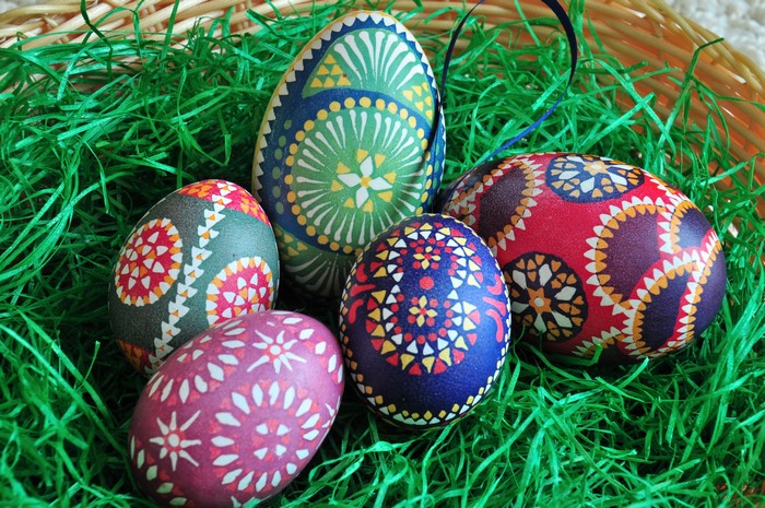 Decorated Easter Eggs in a Basket with Green Grass
