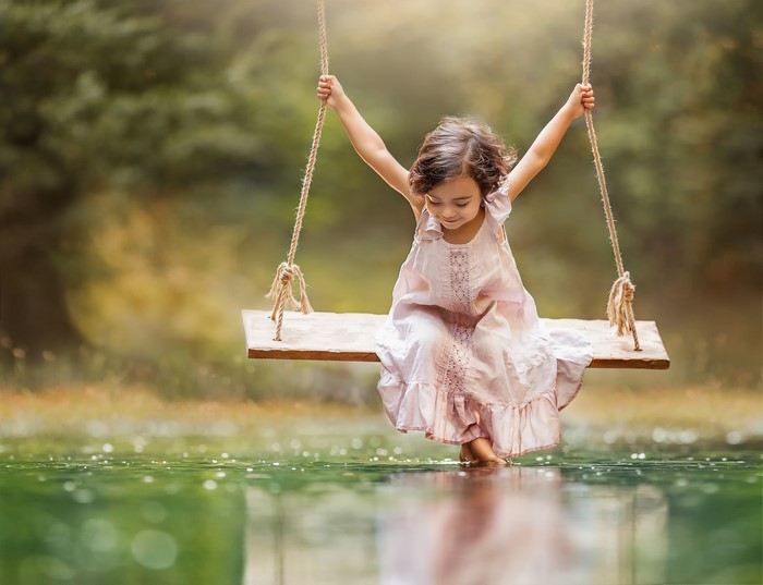 Girl on a swing over water