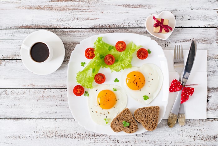Heart-shaped fried eggs with coffee and toast