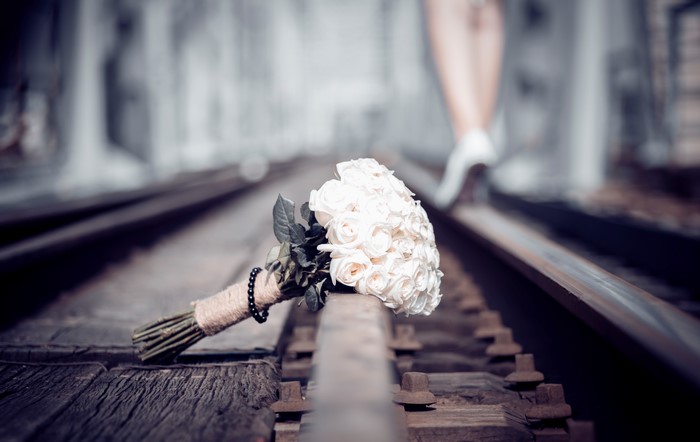 Bouquet on Railroad Tracks with Woman Walking