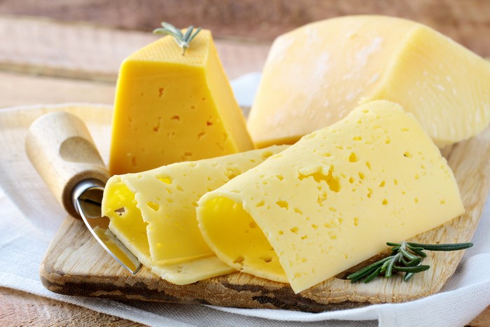 Cheese on a wooden board with rosemary