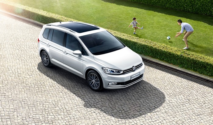 White Volkswagen 2016 Touran L on cobblestone driveway