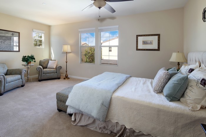 Bedroom with bed, armchairs, and lamps