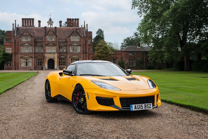 Yellow 2015 Lotus Evora in front of a manor