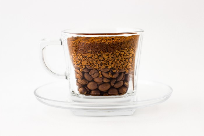 Coffee beans, instant coffee, and ground coffee in a cup