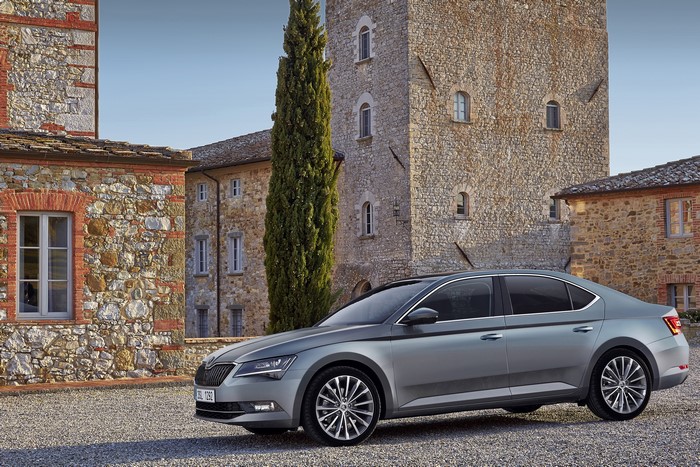 Skoda Superb parked near stone buildings