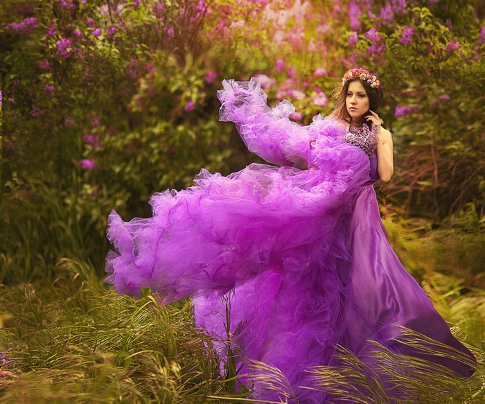 Woman in a flowing purple dress in a lilac field