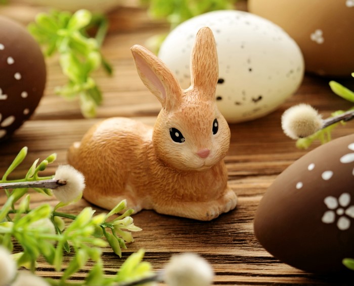 Easter bunny and decorated eggs on wooden table