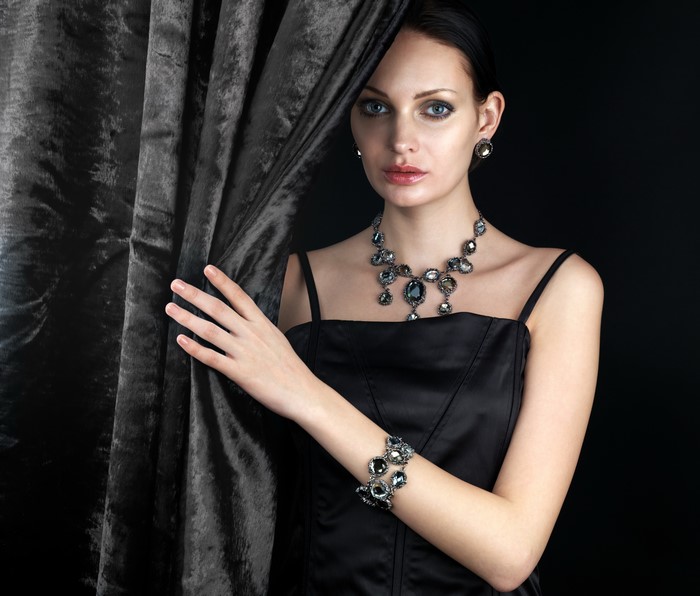 Woman with Jewelry and Dark Curtain